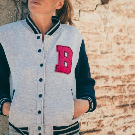 woman wearing light gray cotton varsity jacket