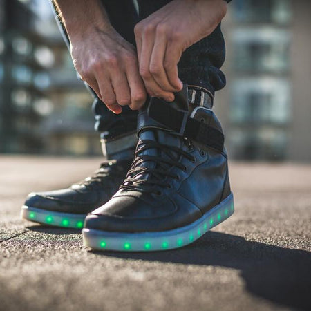 Man doing up his LED high top running shoes
